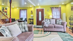 A living room with two sofas, a wooden staircase, and a door with a stained glass window. - 5 Mi to National Mall: Home in Washington DC (Washington)