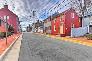 Una calle con edificios rojos y grises, una acera y un cielo despejado.