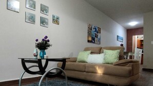 A living room with a brown sofa, a glass coffee table, and a blue rug. - Charming villa in Tulum, near the Tulum Ruins. (Tulum)