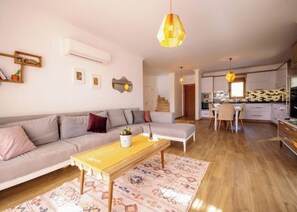 Una sala moderna con sofá, mesa de centro y alfombra.
