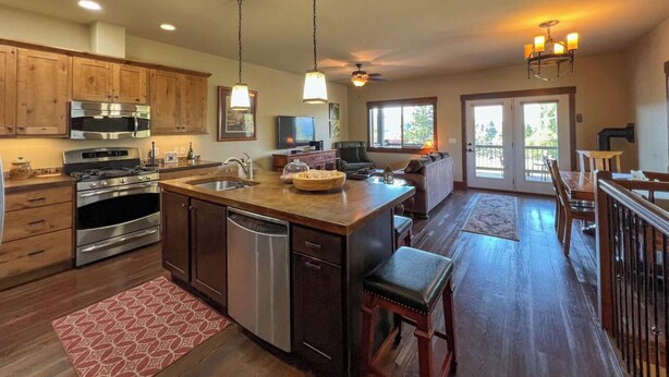 A spacious kitchen with wooden cabinets, stainless steel appliances, and a large island. - Lakeview Getaway-Walk To Downtown Bigfork, Rated #1 Lake town in USA (Bigfork)