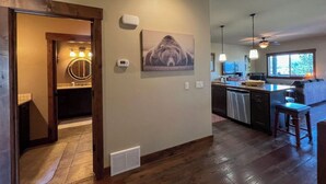 A modern kitchen with a large island, wooden flooring, and pendant lighting. - Lakeview Getaway-Walk To Downtown Bigfork, Rated #1 Lake town in USA (Bigfork)