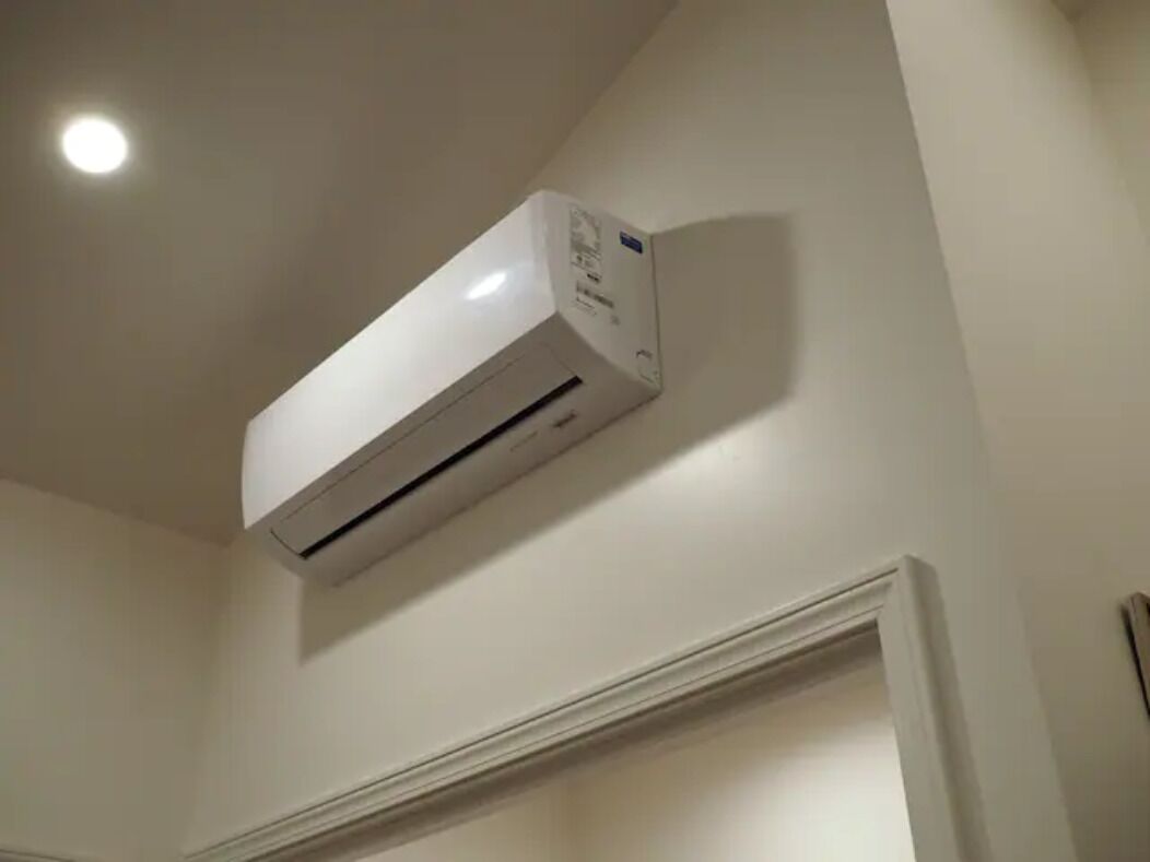 Un equipo de aire acondicionado blanco montado en la pared de una habitación.