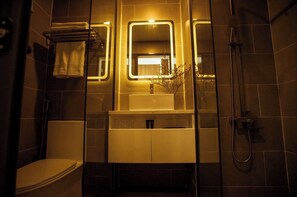 Ein modernes Badezimmer mit Toilette, Waschbecken und Dusche.