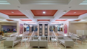 A spacious lobby with a central staircase, multiple seating areas, and a reception desk. - Justiniano Club Alanya (Alanya)