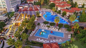 A resort with multiple swimming pools, outdoor seating areas, and lush greenery. - Justiniano Club Alanya (Alanya)