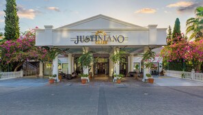 A building with a sign reading 'JUSTINIANO CLUB' and a covered entrance with seating. - Justiniano Club Alanya (Alanya)