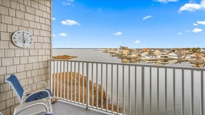 A balcony with a view of a marina and houses across the water.