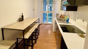 Une cuisine compacte avec une table et des bancs en bois, un plan de travail blanc et une fenêtre donnant sur un beau paysage.