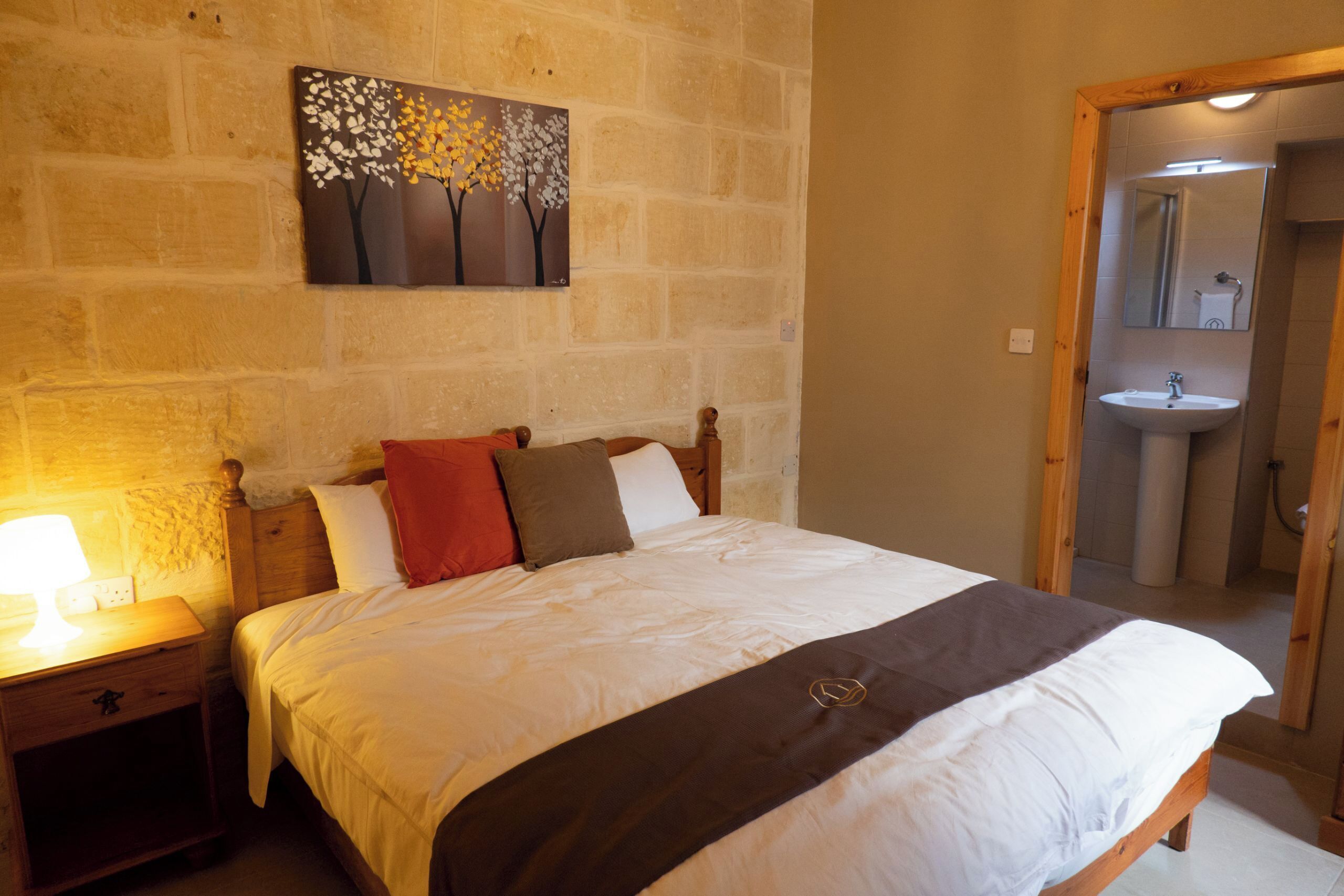 Una camera da letto con un letto, un comodino e un quadro appeso al muro.