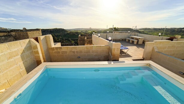 Una piscina en la azotea con vistas al campo.