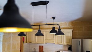 Una cocina con armarios de madera clara, un refrigerador de acero inoxidable, una estufa a gas y un microondas.