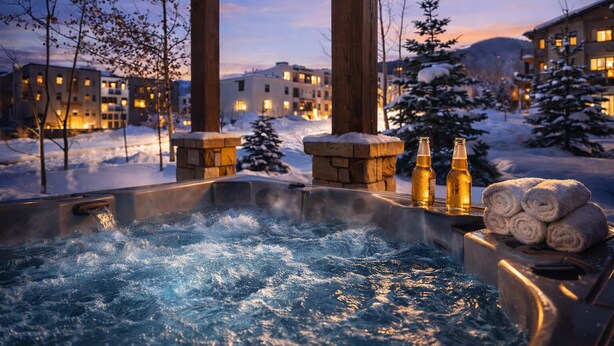 Ein Whirlpool mit Blick auf schneebedeckte Gebäude und Bäume.