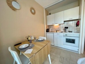 Een koelkast, een oven, een broodrooster, kookgerei, borden en bestek