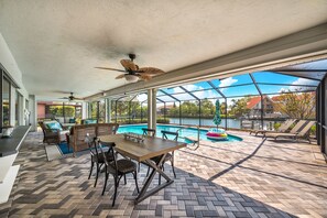 Um alpendre coberto com piscina, área de estar ao ar livre e vista para a água.