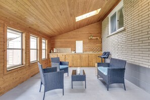 Un interior de madera con muebles de mimbre, una mesita y una ventana.