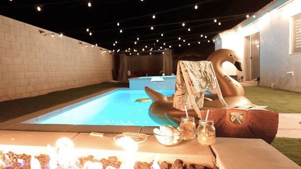 A pool area with a hot tub, string lights, and a fire feature. - Indio Oasis with pool, jacuzzi, gazebo , grill, fire pit and a game room (Indio)