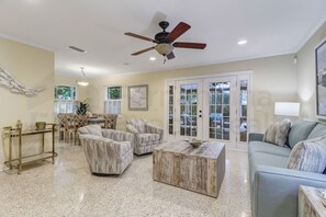 Un salon spacieux doté d’un ventilateur de plafond, d’une table basse et d’un canapé.