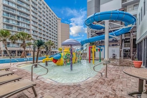 A water park with a colorful water slide and a pool area.