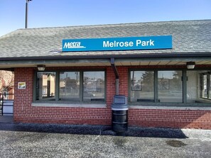 A Metra station named Melrose Park with a brick facade and large windows.