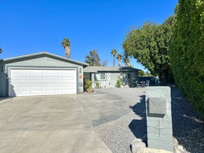 Une propriété résidentielle comprenant un garage, une petite dépendance attenante et une allée aménagée.