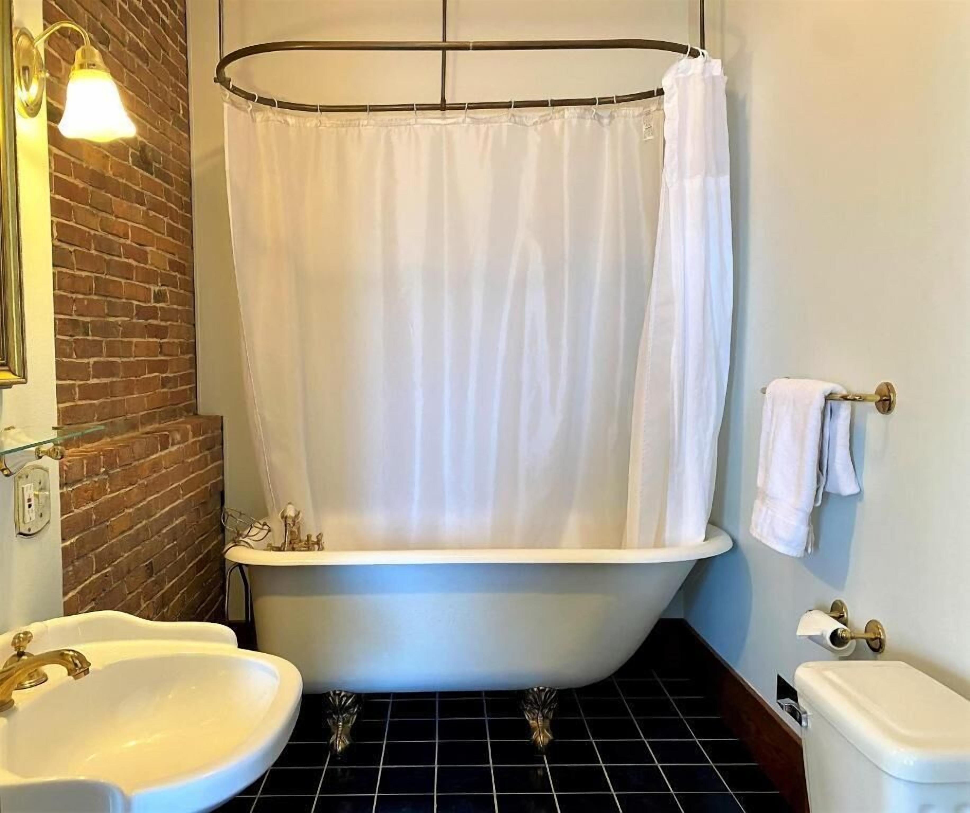 A bathroom with a bathtub, two sinks, and a toilet.