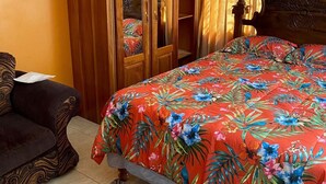 A bedroom with a bed, a wardrobe, and a nightstand.