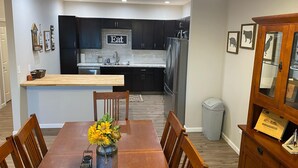 A modern kitchen with dark cabinets, a stainless steel refrigerator, and a sign that says "Eat". - Unique Farmhouse in quiet country setting with beautiful views (La Crosse)