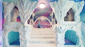 A staircase with ice-like walls and a princess figure in a castle setting. - Grand 8BR Villa by Disney | Pool and Games Room (Kissimmee)