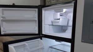 A refrigerator with multiple shelves and compartments, including a freezer section at the top and a main compartment below.
