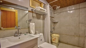 A bathroom with a sink, mirror, towel rack, toilet, and shower. - Attic Cottage by Dumnu Homes (Manali)