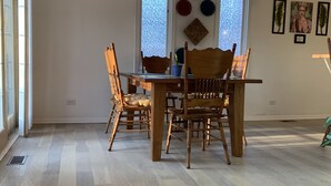 A dining area with a wooden table and chairs, a ceiling fan, and a window with a view of the sky. - Pet Friendly, Near O’Hare, Fenced in, Cheerful Frida & Diego Home, up to 6 ppl (Wood Dale)