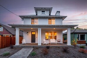 A two-story house with a porch, a covered patio, and a number '145' on the door. - Lodge with Spa, Walk to Old Mill (Bend)
