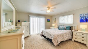 A bedroom with a bed, nightstands, a dresser, a ceiling fan, and a window with blinds. - Manistique Lake Retreat w/ Dock! (Germfask)