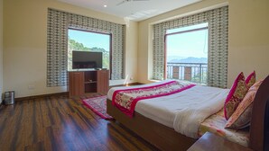 A bedroom with a large bed, a TV, and a balcony view. - Alayam 3 BHK by Dumnu Homes (Krishangarh)