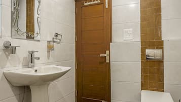A bathroom with a white sink, a wooden door, and a toilet.