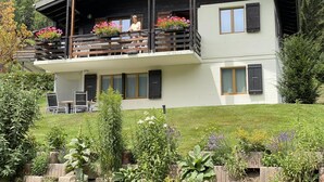 A two-story building with a balcony, wooden railings, and potted flowers. - Apartment Adele by Interhome (Fiesch)