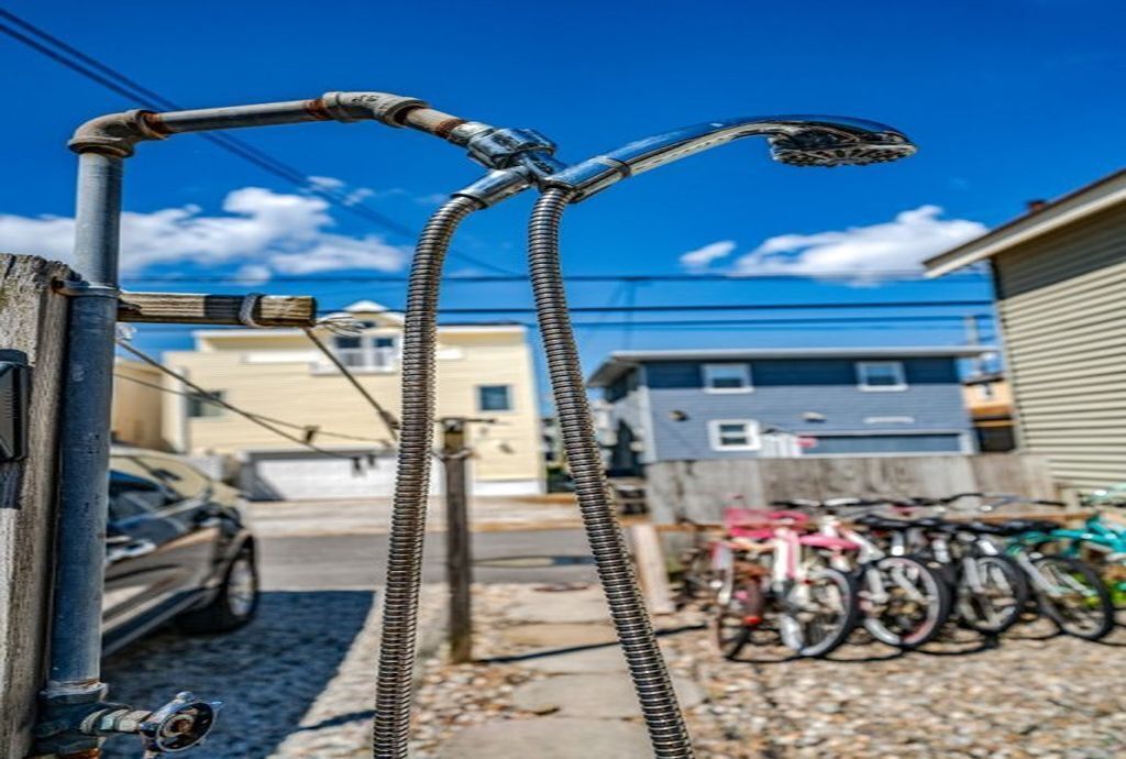 Una struttura metallica con un tubo, un'auto e biciclette sullo sfondo.