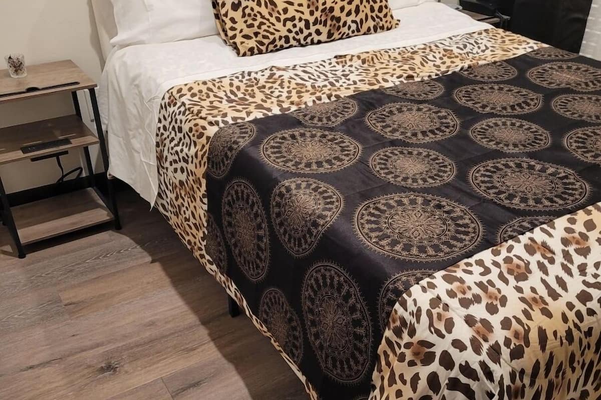 Une chambre d’hôtel équipée d’un lit, d’une table de chevet, d’une lampe et d’un panneau indiquant la sortie de secours.