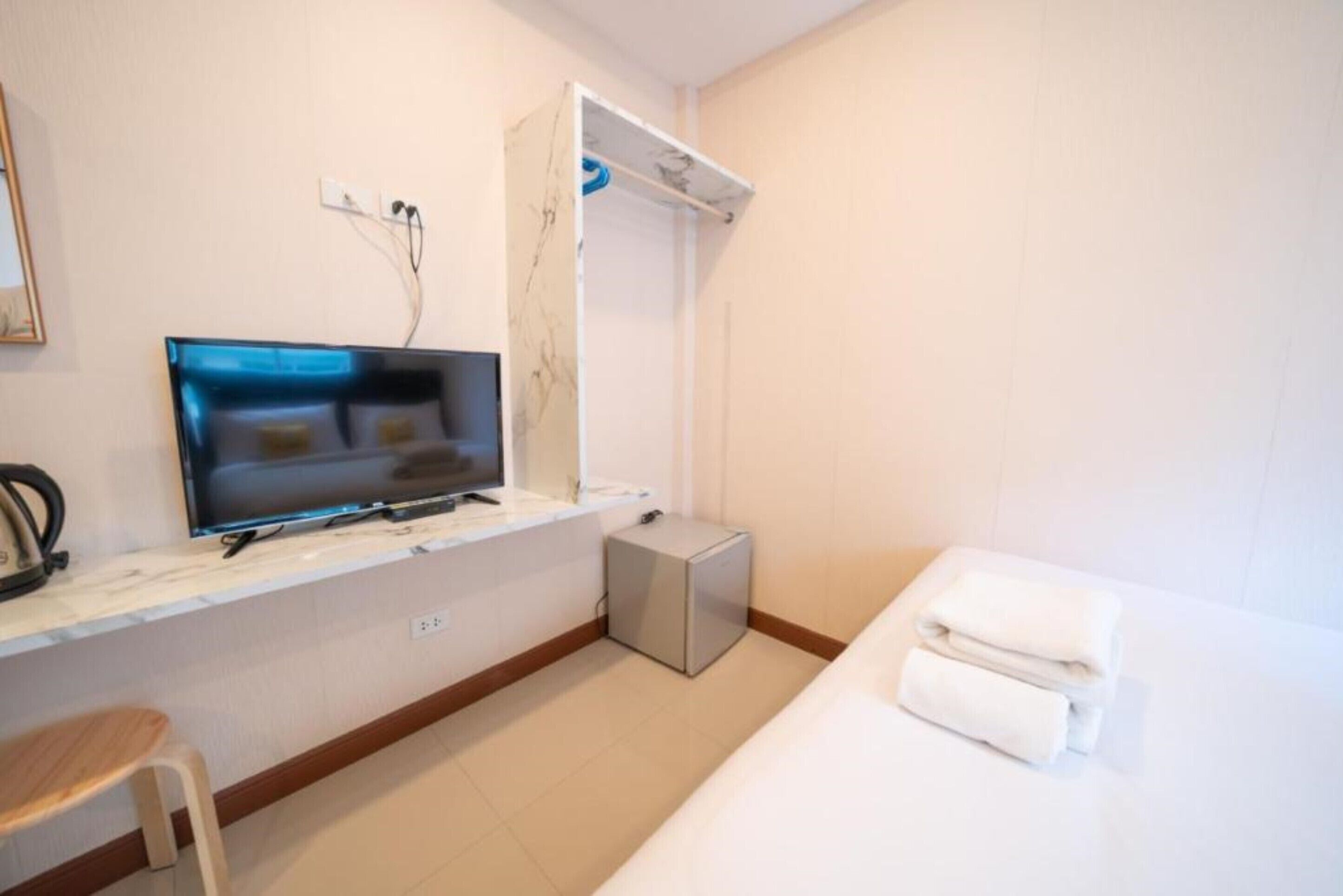 A hotel room with a bed, a TV, a small desk, and a chair.
