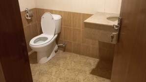 Ein kleines Badezimmer mit Toilette, Waschbecken und Fliesen.