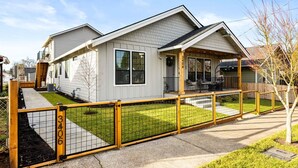 A two-story house with a covered porch and a fenced yard. - New Build, Great Value near Downtown Vancouver & Waterfront (Vancouver)
