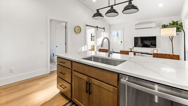 A modern kitchen with a large island, stainless steel appliances, and wooden cabinetry. - New Build, Great Value near Downtown Vancouver & Waterfront (Vancouver)
