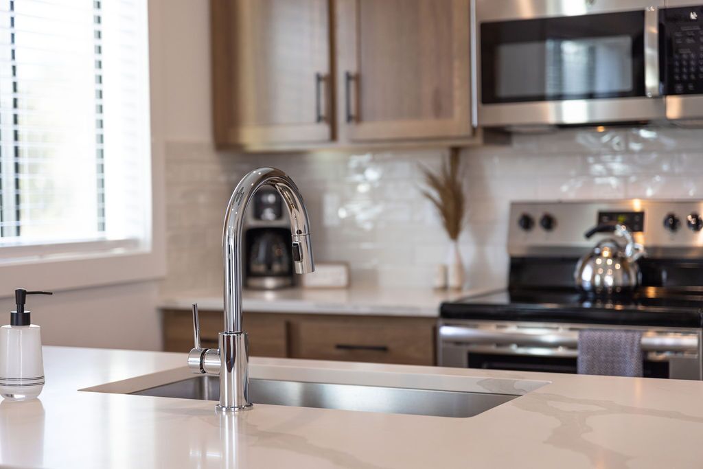 A modern kitchen with stainless steel appliances, a built-in sink, and wooden cabinets.