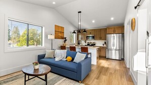 A modern kitchen with a central island, wooden cabinets, and stainless steel appliances. - New Build, Great Value near Downtown Vancouver & Waterfront (Vancouver)