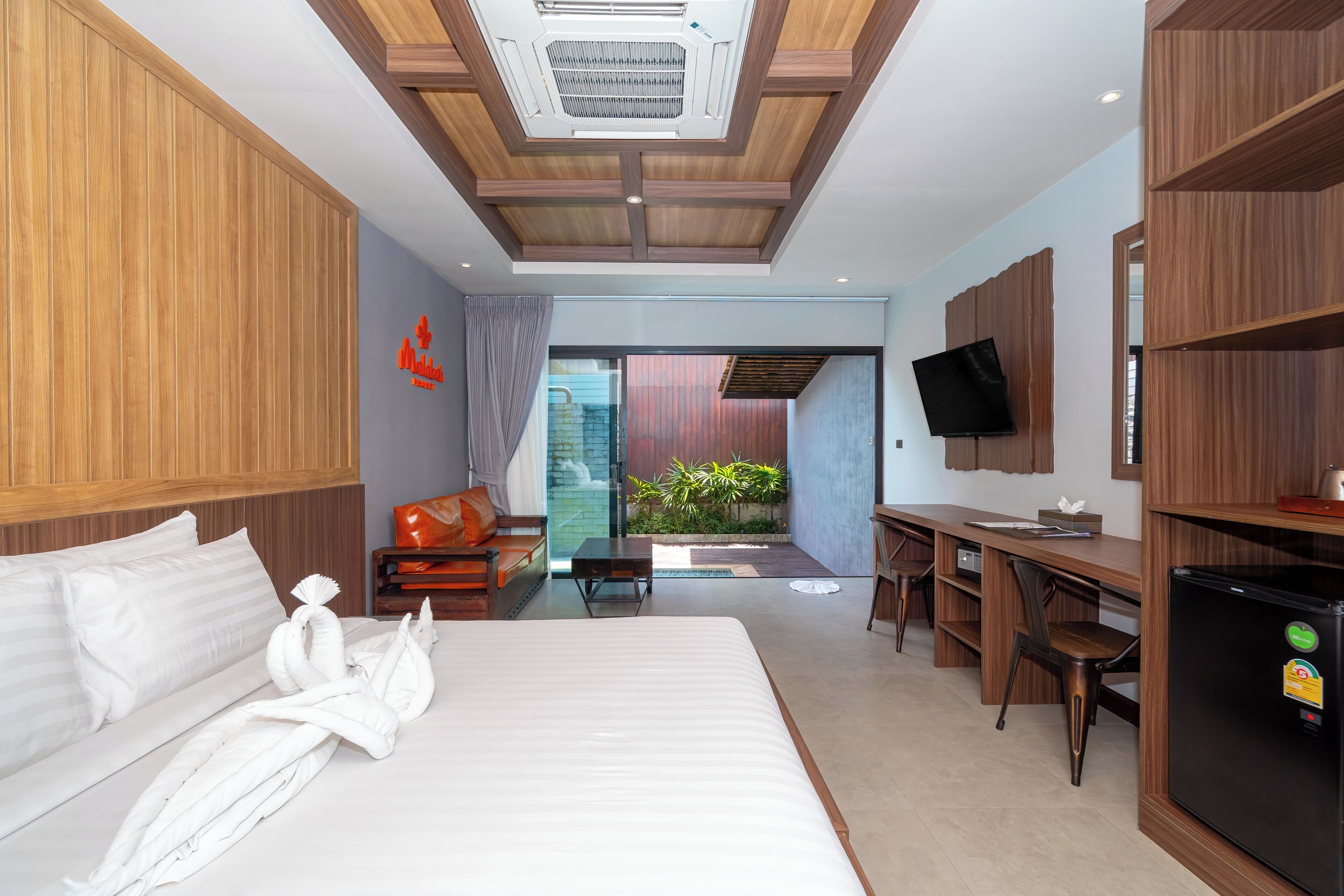 A modern hotel room with a large bed, a desk, and a TV.
