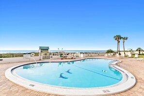 Relax by the pool surrounded by ocean views and lounge chairs.