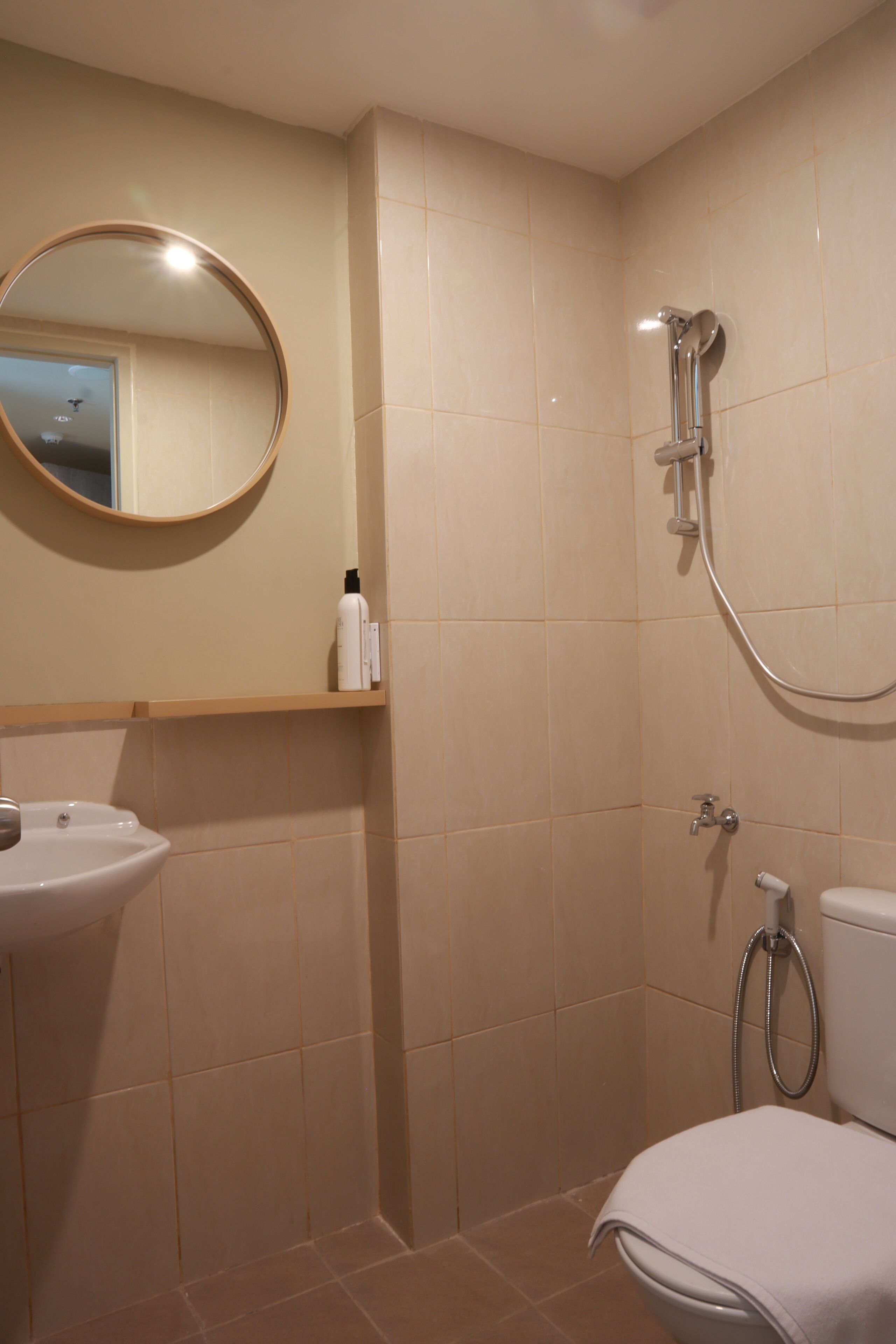 Un bagno con lavandino, specchio, doccia e wc.