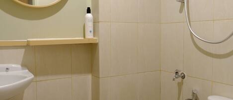 Ein Badezimmer mit Waschbecken, Spiegel, Toilette und Dusche.