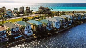 A coastal residential area with houses along a waterfront, featuring a clear view of the ocean. - Waterview Villa~Steps to Beach~Pool~King Bed (Destin)